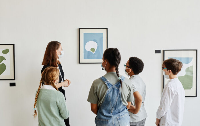 A teacher talking to a group of children about a piece of art in an art gallery