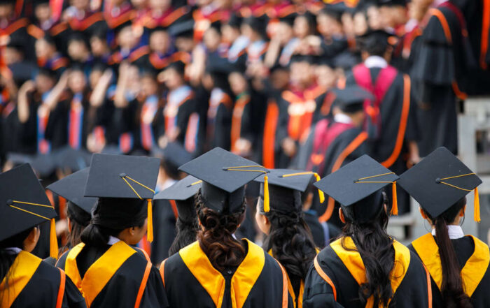 Graduates standing in a line facing the stage