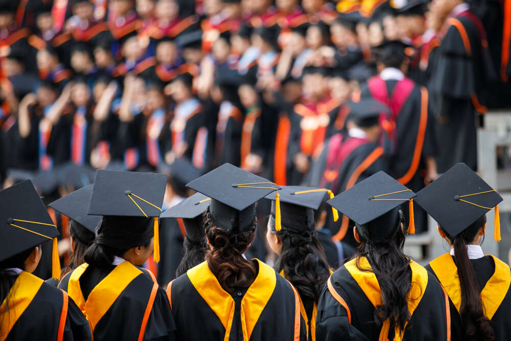 Graduates standing in a line facing the stage